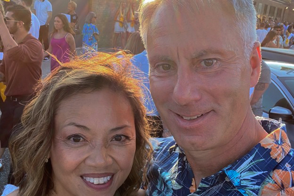 Woman and man outdoors, smiling at camera.